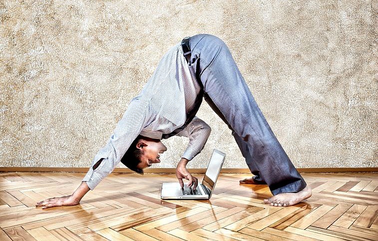 yoga-voor-mannen-wereld-van-yoga-zakenman-doet-yogahouding-en typt-op-laptop Yoga voor mannen: niet voor watjes - Wereld van Yoga