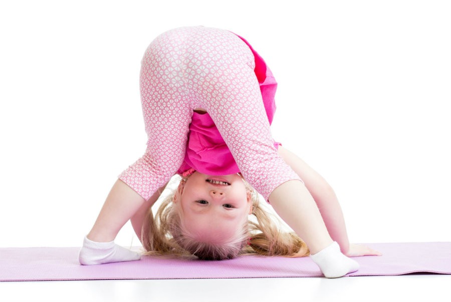 wat is kinderyoga meisje doet yoga ondersteboven Wat is Kinderyoga? - Wereld van Yoga